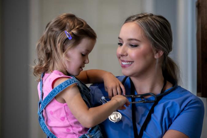 Mother who is a nurse holds daughter before her shift.