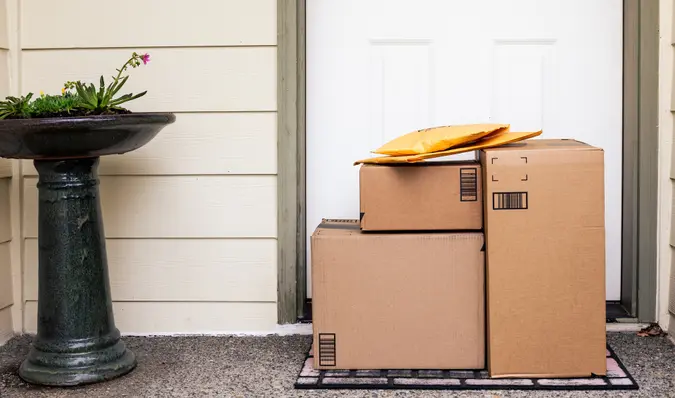 Front Door of House with Stack of Delivery Boxes from Online Ordering and E-commerce.