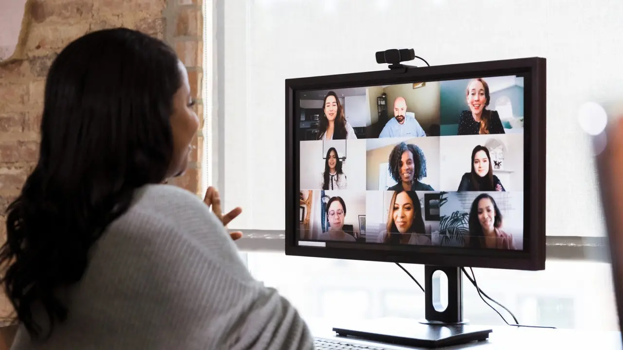 A multi-ethnic team of co-workers meet together via video conferencing.