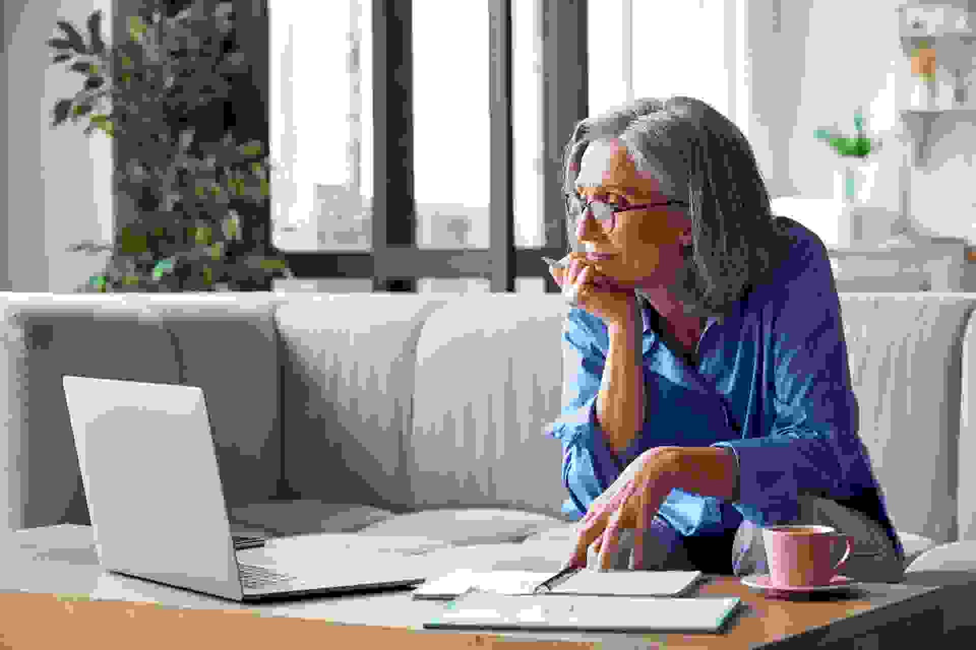 Senior mature older woman watching business training, online webinar on laptop computer remote working or social distance learning from home.