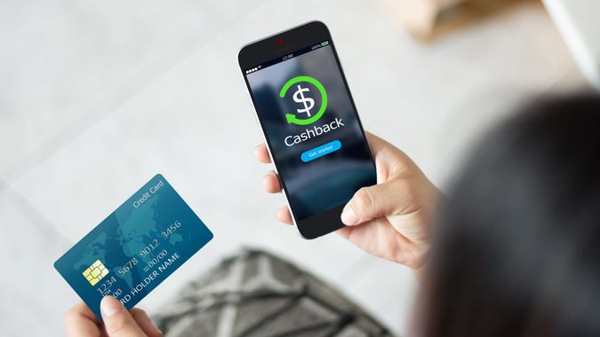 Female hands using mobile phone and holding credit card.