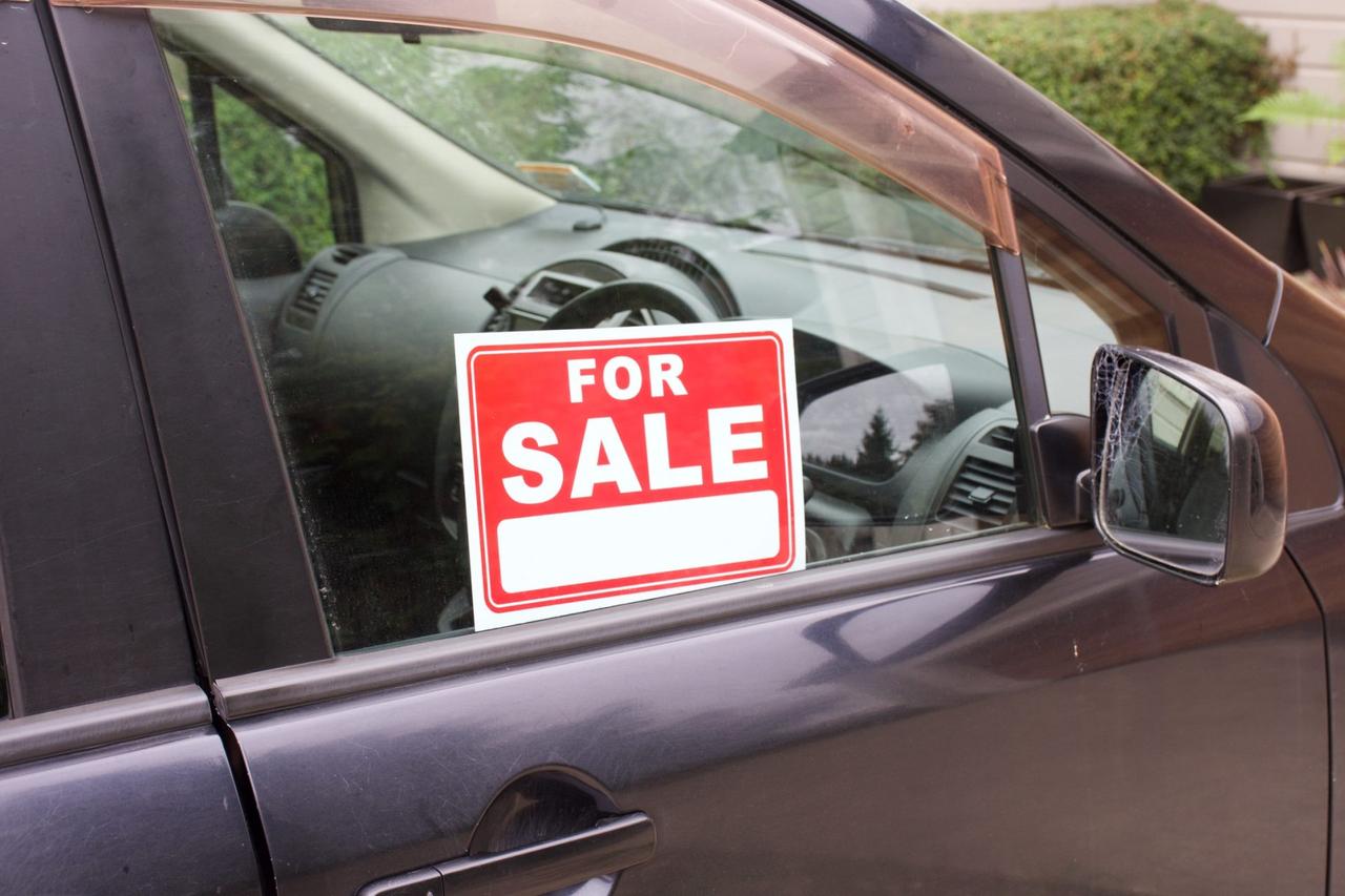 A For Sale sign in a car window.