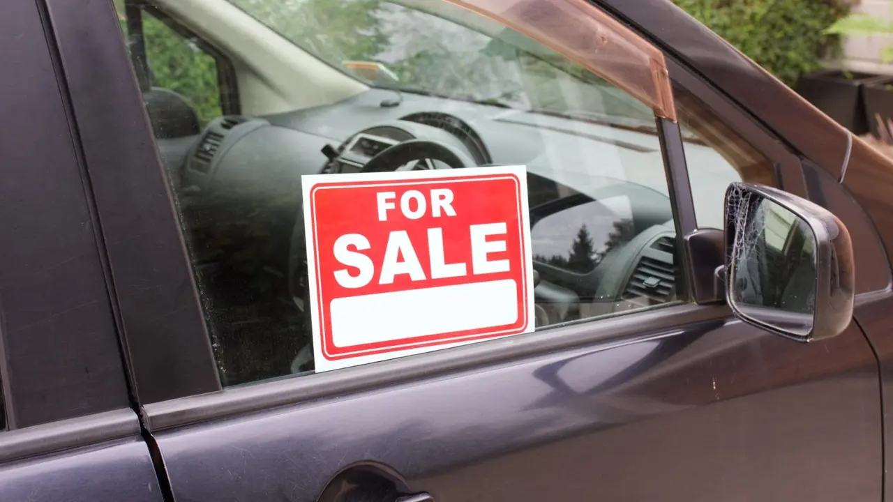A For Sale sign in a car window.