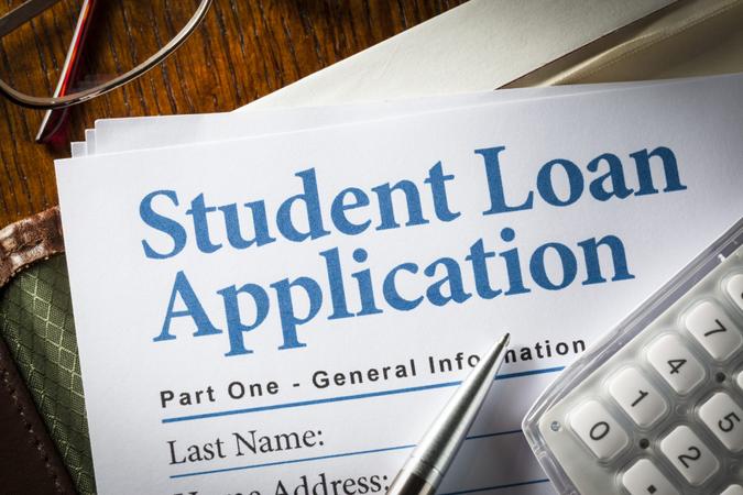 Student Loan Application with pen, calculator and glasses.