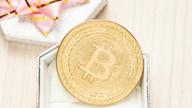 Golden virtual coin bitcoin and gift box with pink ribbon. trendy gift. stock photo