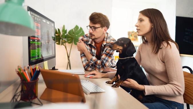 Two young people trading cryptocurrencies on a computer together stock photo