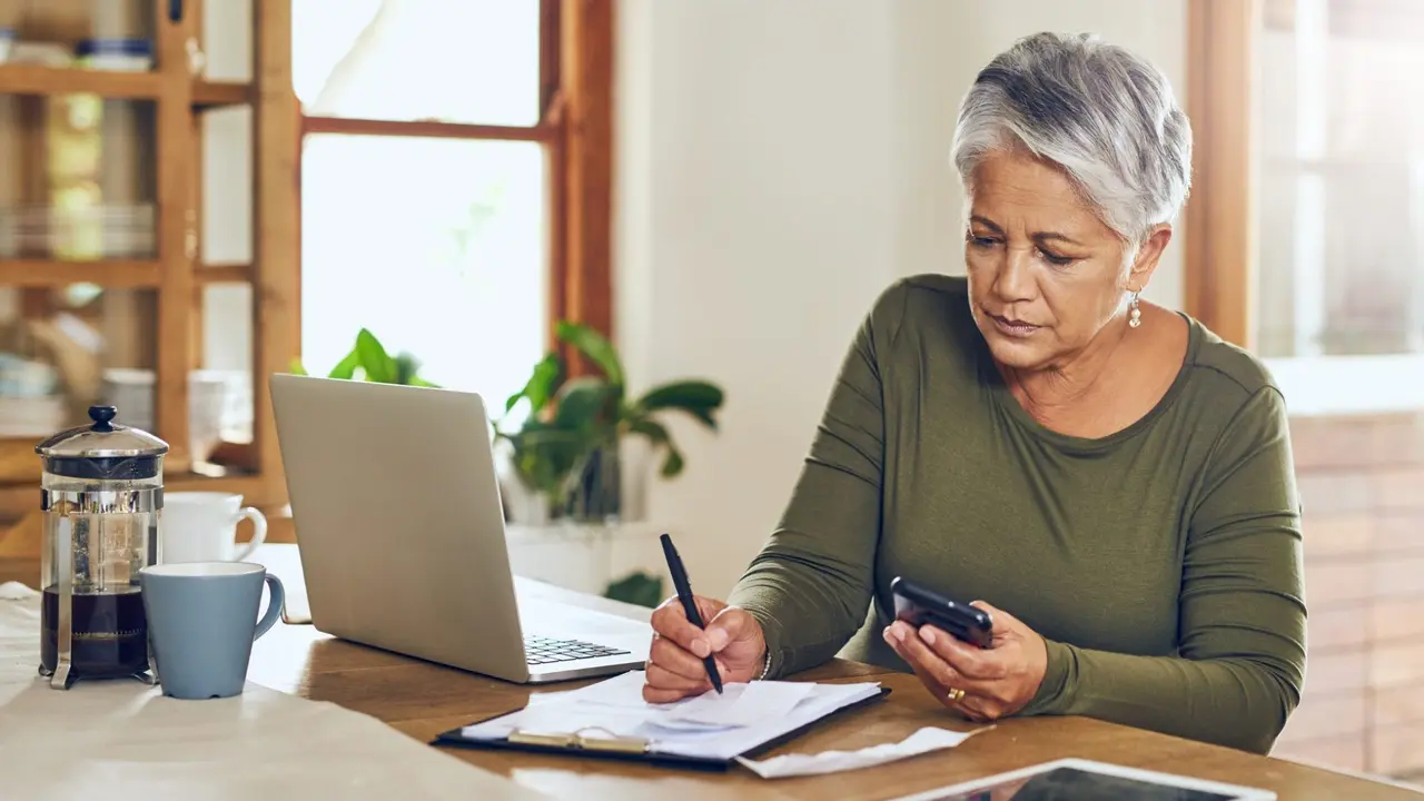 Shot of a mature woman going through paperwork at home.