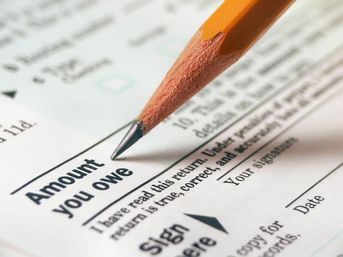 macro of tax form with pencil pointing to ""amount you owe"".