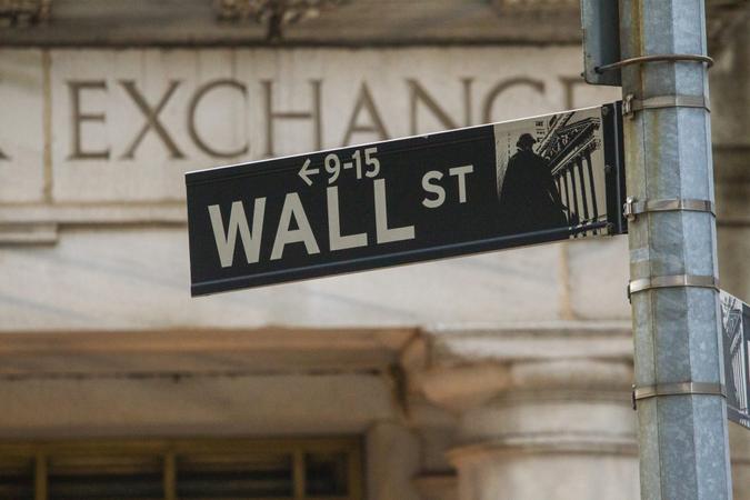 The New York street sign showing Wall Street outside the New York Stock Exchange.