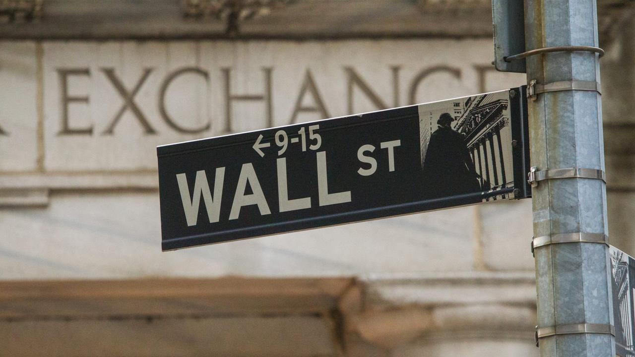 The New York street sign showing Wall Street outside the New York Stock Exchange.