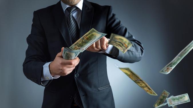 Businessman throwing dollar banknotes in air stock photo