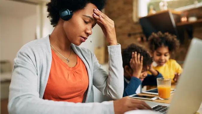 Black single mother feeling frustrated while working at home. stock photo