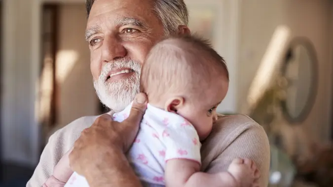 Hispanic grandfather holding his baby grandson, head and shoulders, close up stock photo