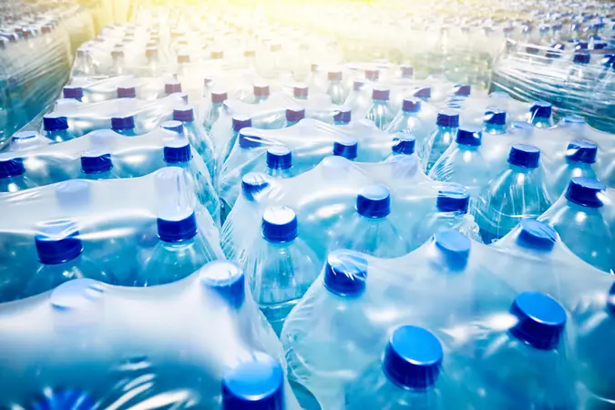 Many packaged blue mineral water bottles in stock in a store or market.
