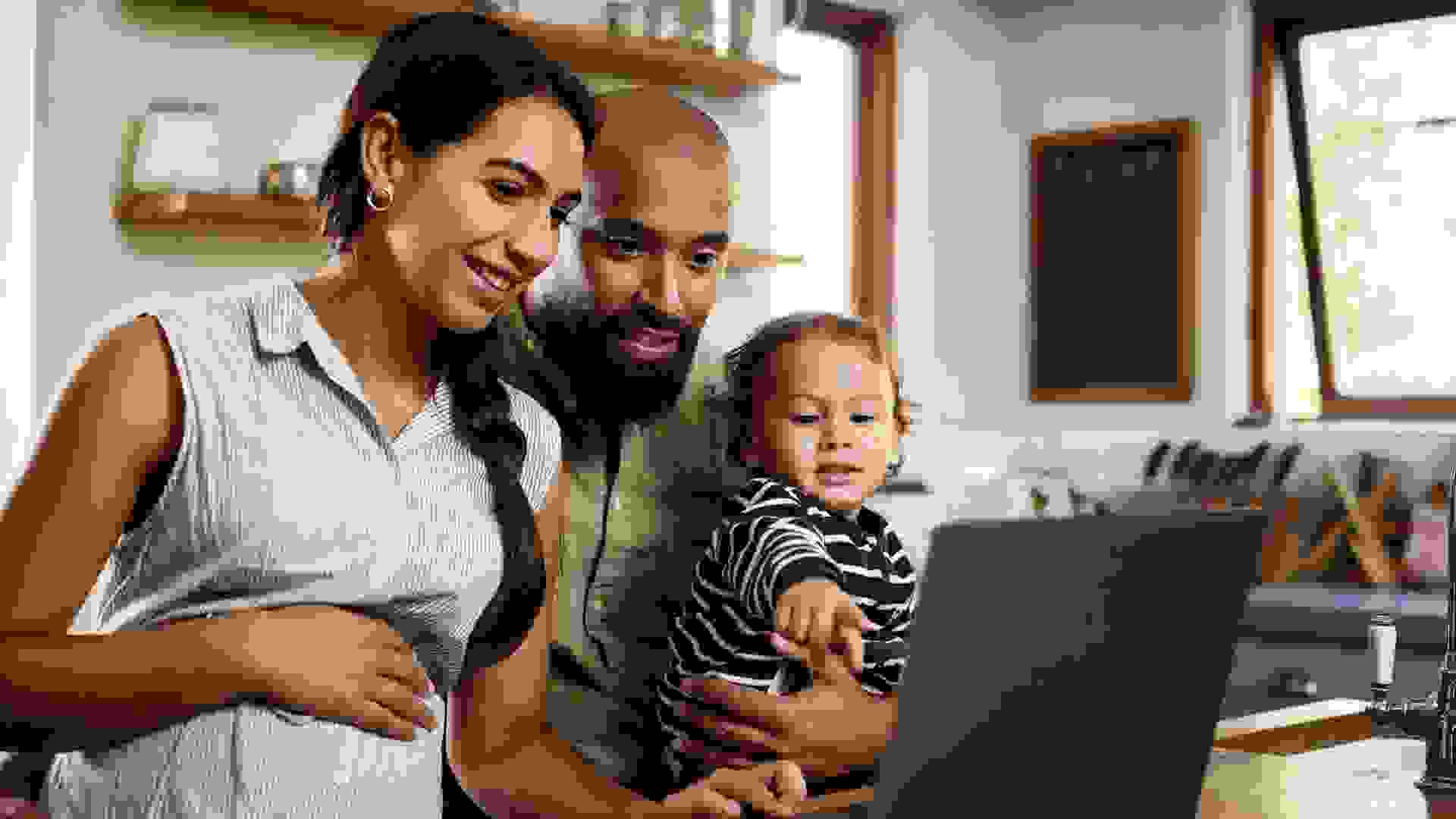 Shot of a happy young family using a laptop together at home.