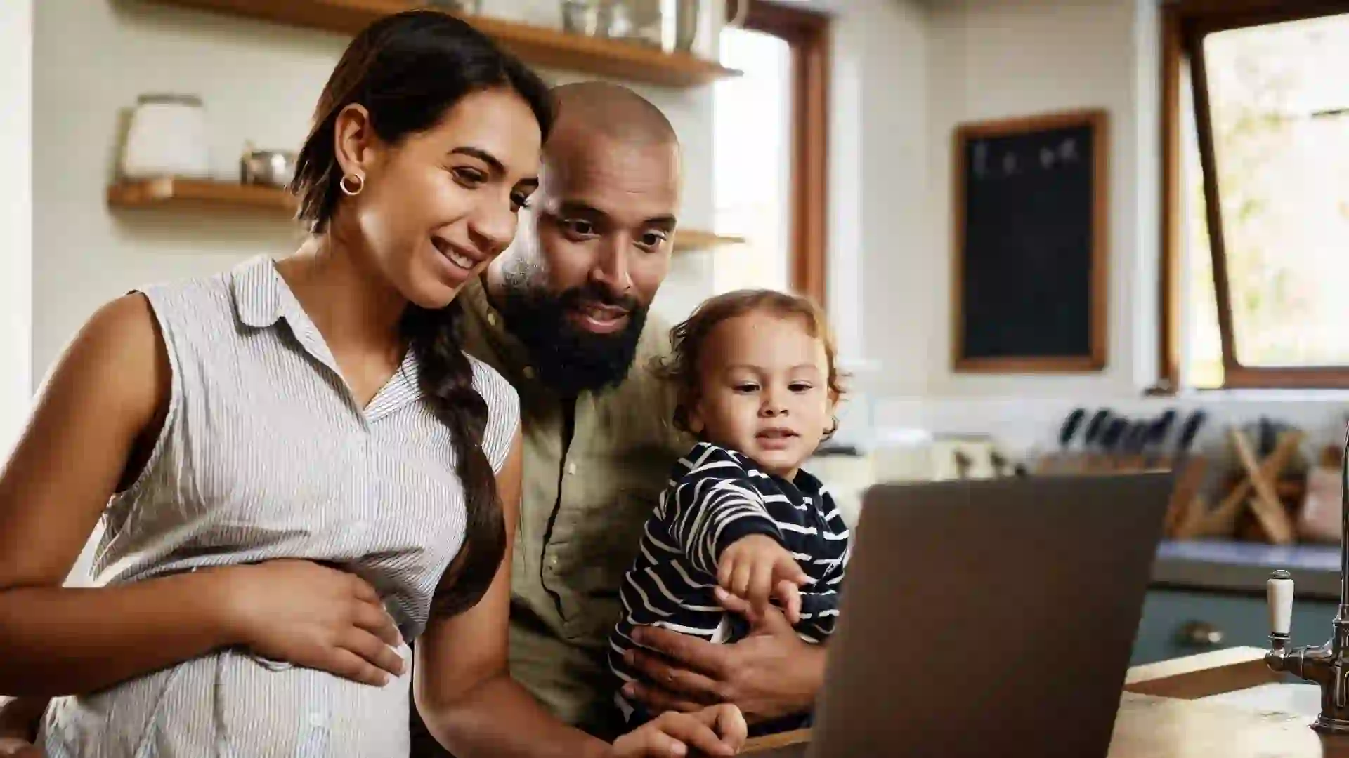 Shot of a happy young family using a laptop together at home.