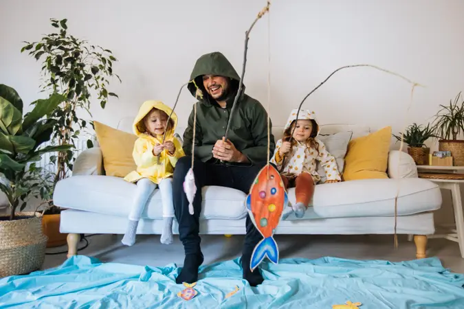 Happy child and young father with inflatable ring and drawing tropical fishes around him.