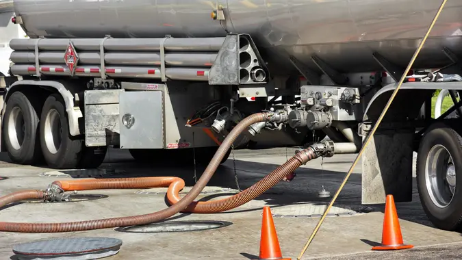 Fuel tanker deposits gasoline into storage tank at the gas station.