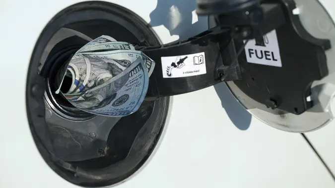 Gas Prices Concept: Gas tank eats money stock photo