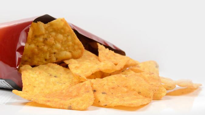 Open bag of crisps in a white back ground stock photo