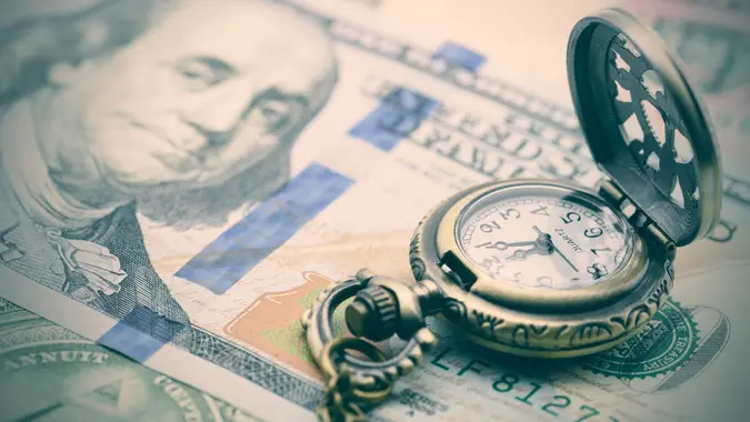 Classic pocket watch on a hundred US dollar bill. stock photo