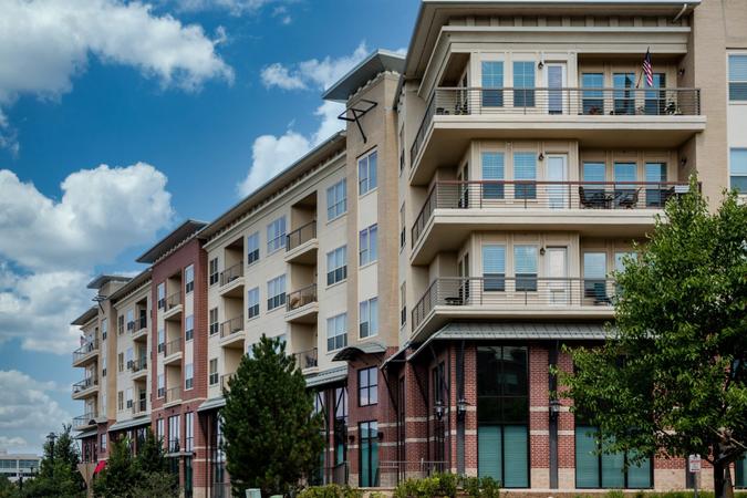 Modern brick and stucco condo buildings with balconies and garages.