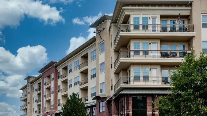 Modern brick and stucco condo buildings with balconies and garages.