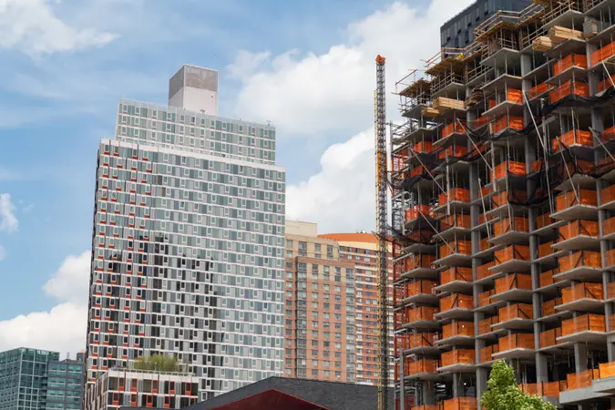 Modern glass residential buildings with a skyscraper under construction in Long Island City Queens New York.