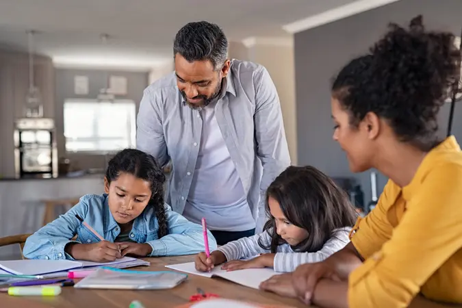 Indian parents helping children with their homework at home.