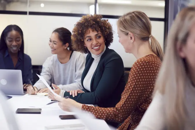 Group Of Businesswomen Collaborating In Creative Meeting Around Table In Modern Office.