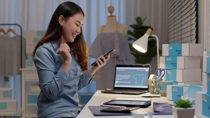 Young attractive beautiful female entrepreneur fund borrower crazy joyful ecstatic face gesture hand yes feeling amazed in peer to peer P2P lending finance or crowdfunding network microfinance approve.