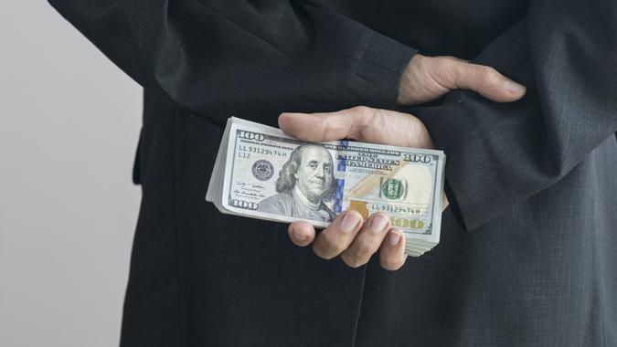 Corruption concept by business man is hide the money at back. stock photo