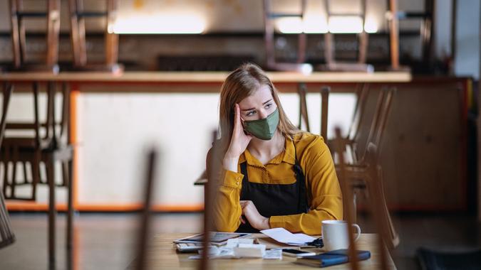 Frustrated owner sitting at table in closed cafe, small business lockdown due to coronavirus. stock photo