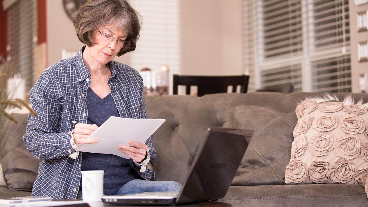Senior adult woman works from home using laptop computer.