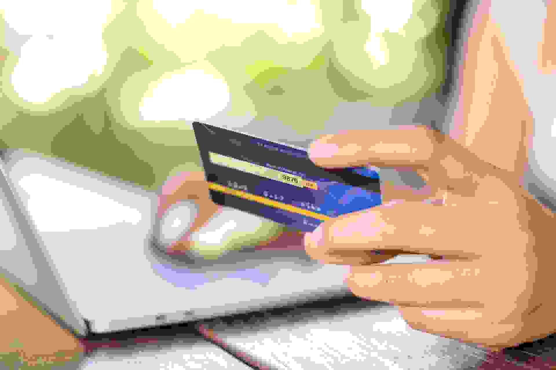 Girl buying online with credit card and a tablet sitting in the garden at home in holiday, Online Shopping Concept.