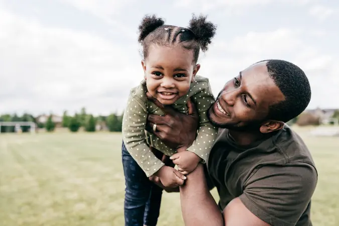 Dad spending time with baby daughter outdoor.