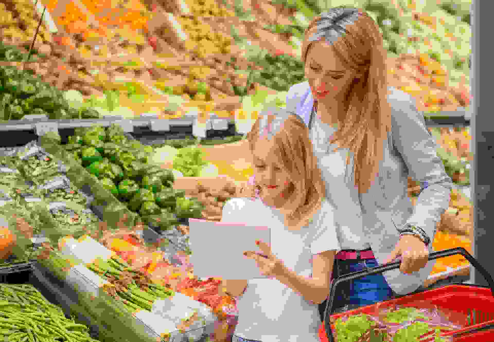 Mother and daughter shopping vegetables groceries store.