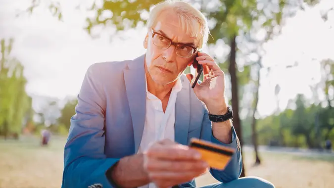 Senior man phoning the bank for credit card support.