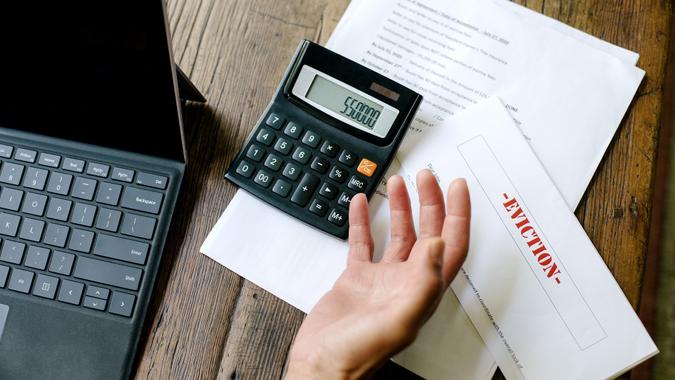 Eviction Notice and Bills To Pay - Hands of a Woman - Laptop - Calculator stock photo