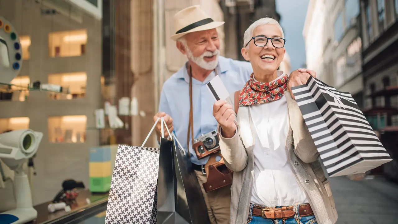 A happy retired couple goes shopping while they travel and enjoy their vacation.
