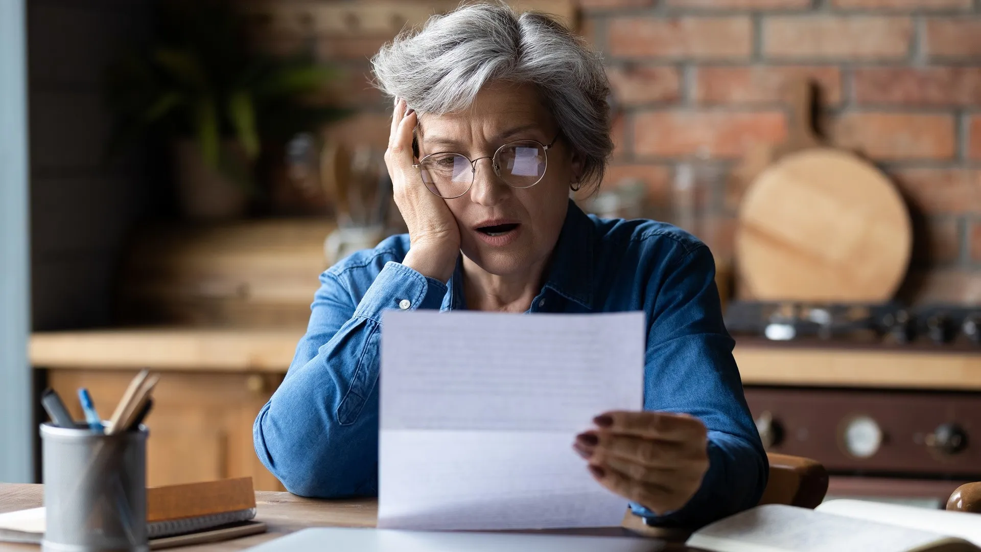 不快乐的成年人戴着眼镜阅读坏消息在信的股票照片