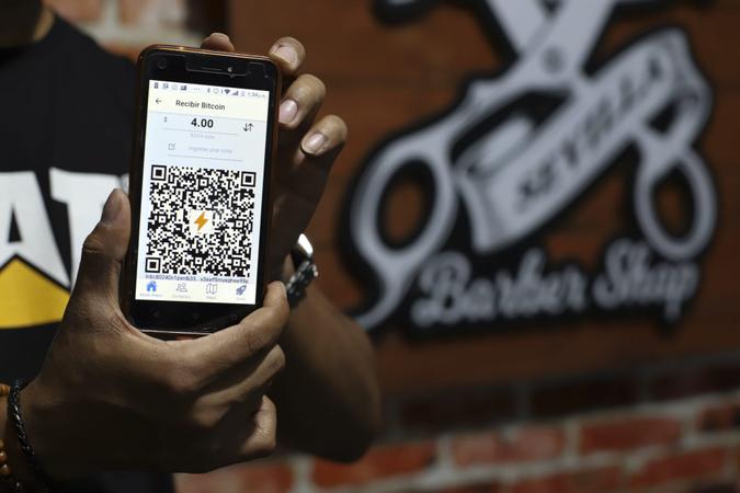 Mandatory Credit: Photo by Salvador Melendez/AP/Shutterstock (12419833a)Barber Shop worker shows his shop's unique QR code for Bitcoin payments in Santa Tecla, El Salvador, .