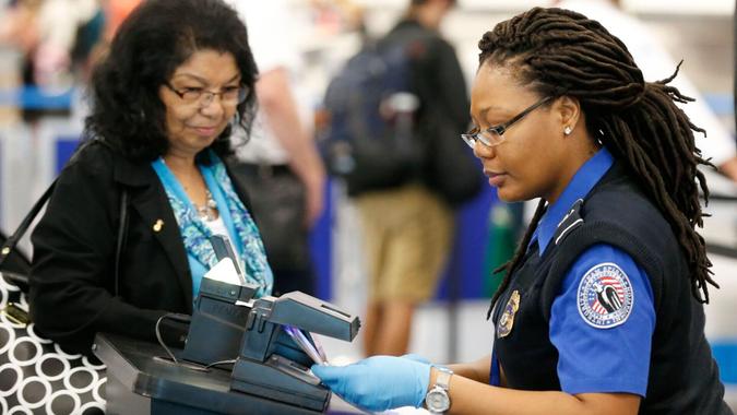Mandatory Credit: Photo by AP/Shutterstock (8785304k)A TSA officer scans a traveler's documents at a checkpoint, at Miami International Airport in Miami.