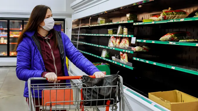Woman with protection face mask and gloves shopping at supermarket. stock photo