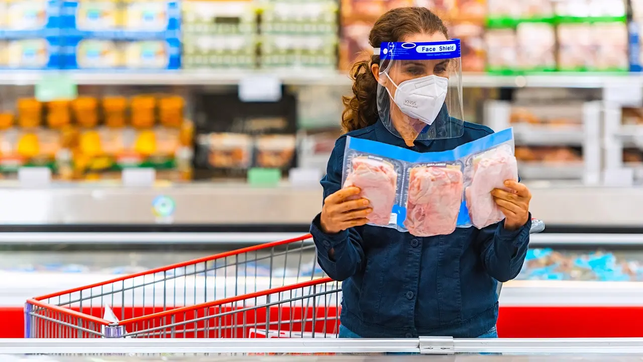 Mature woman shopping for frozen chicken at a supermarket stock photo