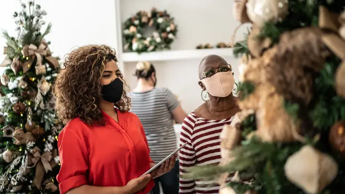Saleswoman supporting a customer in a christmas ornament store stock photo