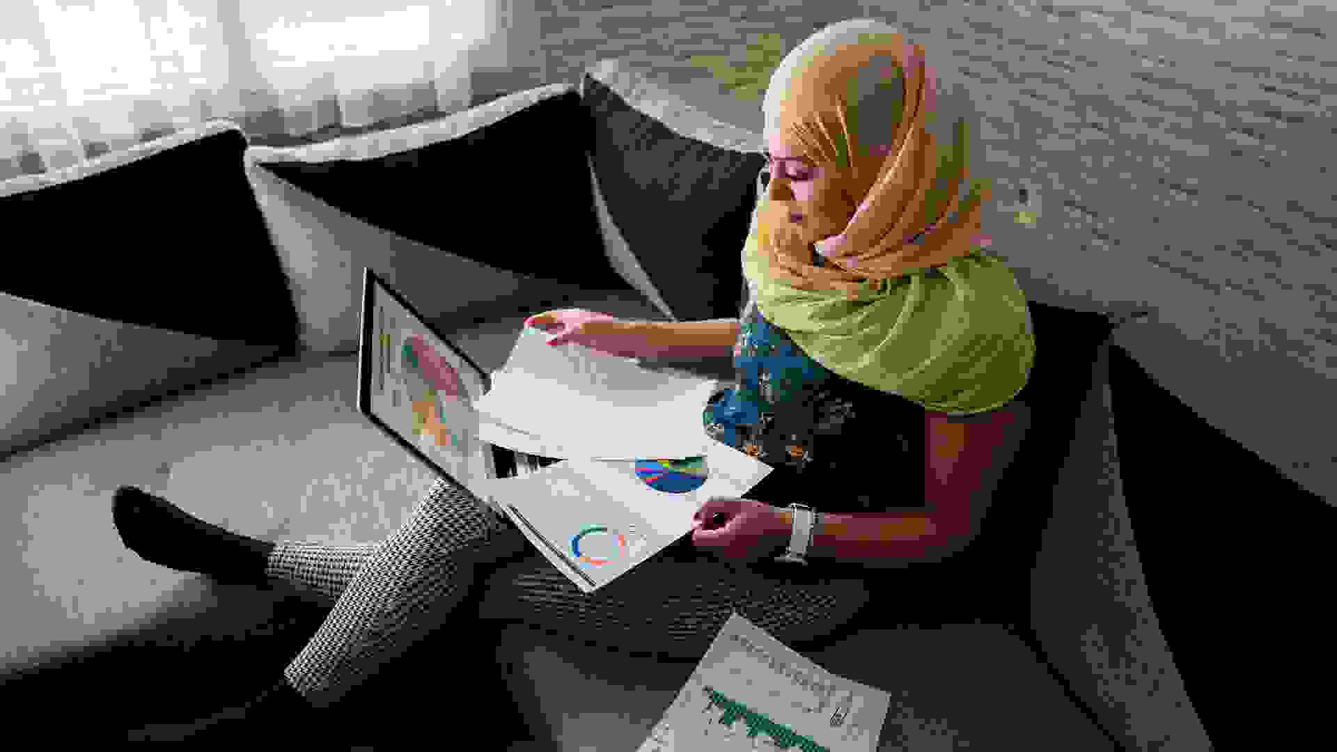 Islamic business woman investing online from home.