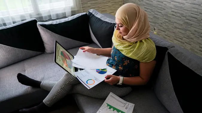 Islamic business woman investing online from home.