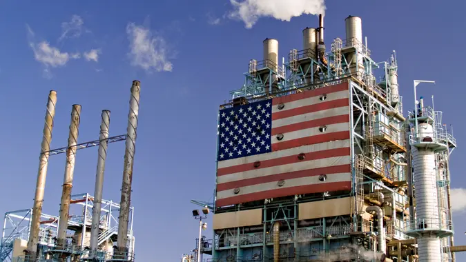 Part of oil refinery complex with big american flag displayed.