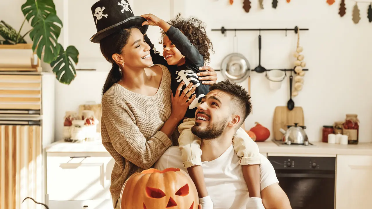 happy multiethnic family mother, father and little son have fun and celebrate Halloween at home.